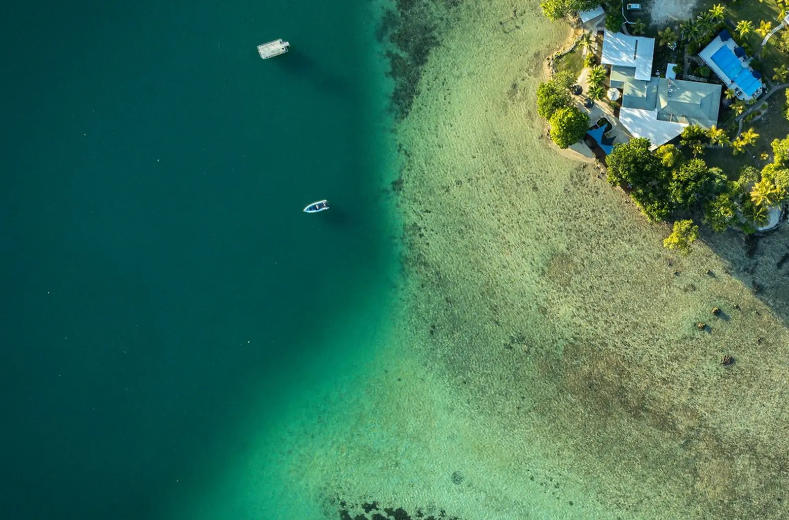 Eine helle Sandbank zwischen tiefblauem und türkisem Wasser in einer Lagune auf Espiritu Santo