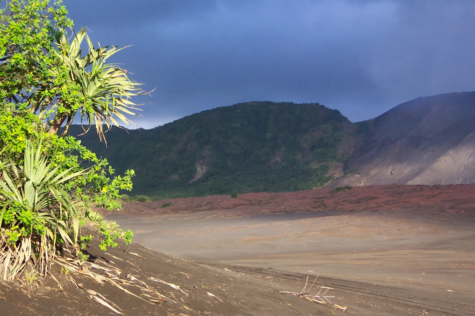 Grüne Hügel und die Ascheebene am Fuß des Mount Yasur auf Tanna